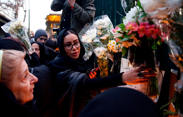 Des Iraniens transportent des fleurs pour les victimes du Boeing 737 d'Ukraine International Airlines lors d'un rassemblement devant l'Université Amirkabir dans la capitale Téhéran, le 11 janvier 2020. (Photo : AFP via Getty Images)