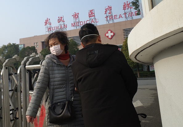 -Une femme quitte le centre de traitement médical de Wuhan, où un homme est décédé des suites d'une maladie respiratoire, dans la ville de Wuhan, province du Hubei, le 12 janvier 2020. Photo de Noel Celis / AFP via Getty Images.