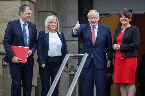 Le Premier ministre britannique Boris Johnson (droite) et le secrétaire britannique à l'Irlande du Nord Julian Smith (gauche) se tiennent avec le premier ministre d'Irlande du Nord Arlene Foster (2e droite) et la vice-première ministre Michelle O'Neill (2e gauche) a à Belfast le 13 janvier 2020. (Photo : PAUL FAITH/AFP via Getty Images)