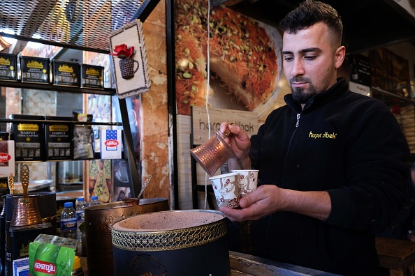 -Un Kurde irakien prépare du café syrien dans une boutique du bazar central d'Arbil, capitale de la région autonome kurde du nord de l'Irak, le 21 décembre 2019. Les deux communautés parlent des dialectes distincts et ont des habitudes culturelles différentes, mais ces dernières années, elles ont échangé des coutumes. Photo par SAFIN HAMED / AFP via Getty Images.