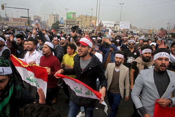 -Des manifestants anti-gouvernementaux irakiens défilent avec des drapeaux nationaux alors qu'ils se rassemblent pour protester sur la place Tayaran, près de la place Tahrir dans le centre de la capitale Bagdad le 19 janvier 2020. Photo SABAH ARAR / AFP via Getty Images.-
