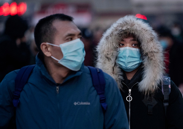 Les voyageurs chinois portent des masques de protection à leur arrivée à bord des trains à la gare de Pékin avant la fête annuelle du printemps le 21 janvier 2020 à Pékin. (Photo : Kevin Frayer/Getty Images)