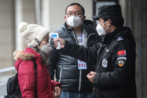 Le personnel de sécurité vérifie la température des passagers sur le quai du fleuve Yangtze le 22 janvier 2020 à Wuhan, province du Hubei, Chine.(Photo : Getty Images)