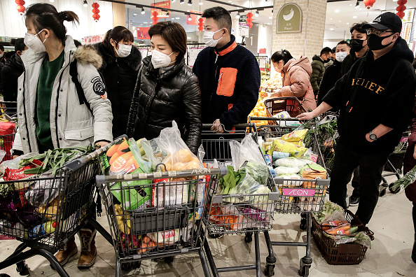 -Les résidents portent des masques pour acheter des légumes sur le marché le 23 janvier, Chine le 23 janvier 2020 à Wuhan. Les vols, les trains et les transports en commun, y compris les bus, les métros et les ferries, ont été temporairement fermés. Photo par Getty Images.