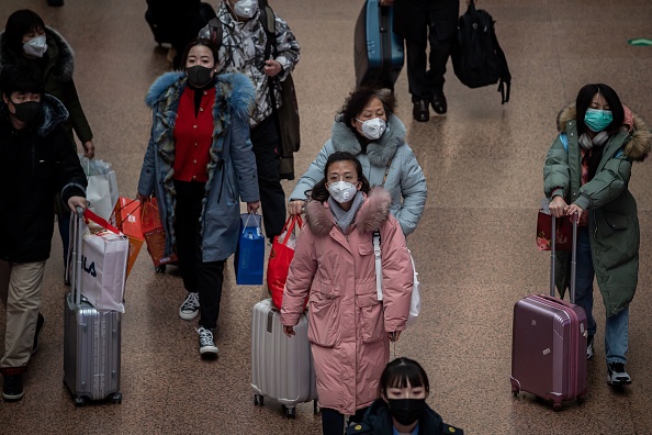 Les personnes portant des masques de protection voyagent pour les vacances du Nouvel An à la gare de Beijing West à Pékin le 24 janvier 2020. (Photo : NICOLAS ASFOURI/AFP via Getty Images)