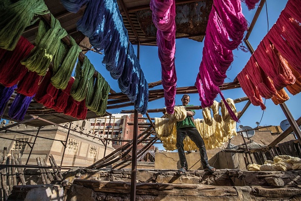 -Mohamed Kamal, un travailleur de la teinture âgé de 59 ans, suspend des fils teints pour sécher au soleil dans un atelier traditionnel de teinture à la main dans le quartier centenaire de Darb al-Ahmar, la capitale égyptienne du Caire, le 21 janvier 2020. Photo par KHALED DESOUKI / AFP via Getty Images.