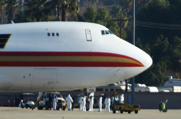 Le personnel en tenue de risque biologique attend les passagers évacués de Wuhan peu de temps après que l'avion a atterri à la base aérienne de March à Riverside, en Californie, le 29 janvier 2020. (Photo : MATT HARTMAN/AFP via Getty Images)