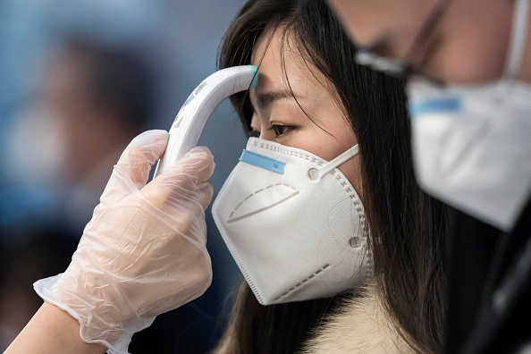 Un passager reçoit un contrôle de la température avant de prendre un vol.  (Photo : Tomohiro Ohsumi/Getty Images)