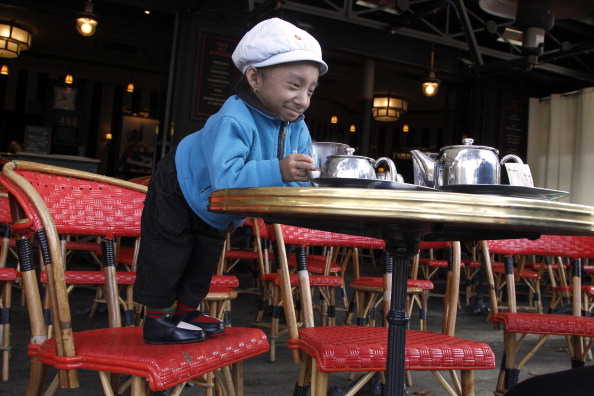 Le détenteur du record du monde de la Guinness népalaise, Khagendra Thapa Magar, 19 ans, le plus petit homme du monde avec 67 cm, prépare du thé dans un café français à Paris le 19 octobre 2011. (Photo : FRANCOIS GUILLOT/AFP via Getty Images)