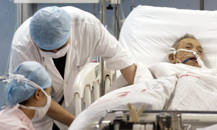 Des infirmières traitent un patient pour une affection inconnue à l'unité de soins intensifs de l'hôpital No1 de Guangzhou, en Chine, le 12 juin 2003. (PETER PARKS/AFP/GettyImages)