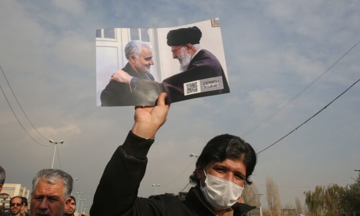 Un homme tient une photo de l'ayatollah Ali Khamenei, chef suprême de l'Iran, avec Qassem Soleimani (à g.), général des Gardiens de la révolution iranienne, lors d'une manifestation à Téhéran, le 3 janvier 2020. (Atta Kenare/AFP via Getty Images)