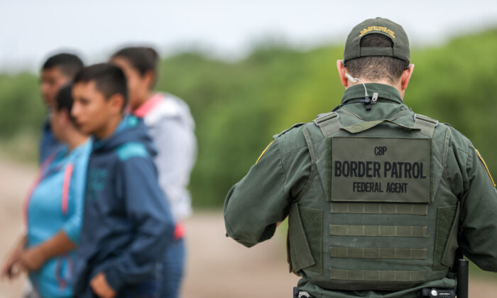 Un agent de la patrouille frontalière appréhende des étrangers en situation irrégulière qui viennent de traverser le Rio Grande du Mexique à Penitas, au Texas, le 21 mars 2019. (Charlotte Cuthbertson/The Epoch Times)
