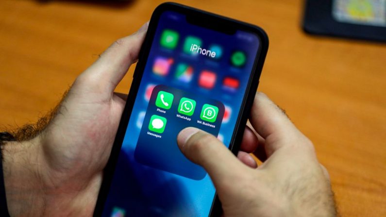 Un homme utilise son smartphone Apple pour accéder à l'application WhatsApp de messagerie et de voix sur IP (VOIP). (JOSEPH EID/AFP via Getty Images)
