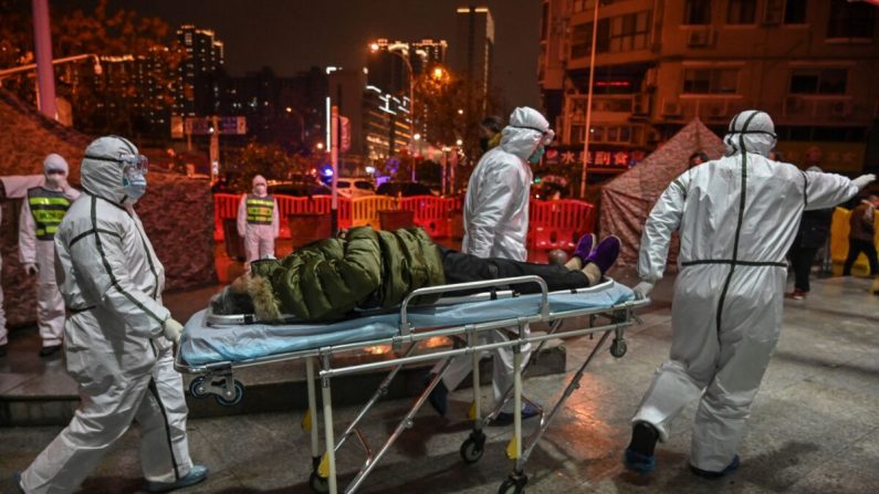 Des membres du personnel médical portant des vêtements de protection pour aider à stopper la propagation du virus mortel apparu dans la ville, arrivent avec un patient à l'hôpital de la Croix-Rouge de Wuhan, en Chine, le 25 janvier 2020. (Hector Retamal/AFP via Getty Images)