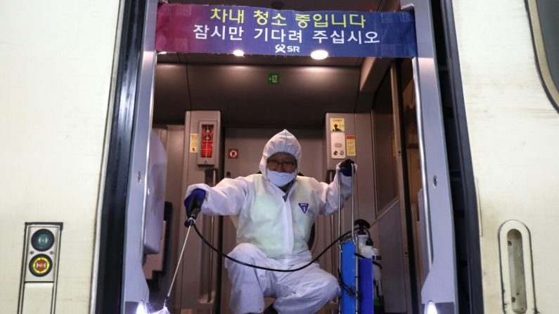 Un travailleur portant un équipement de protection pulvérise une solution antiseptique dans un train au milieu des inquiétudes concernant la propagation du nouveau coronavirus 2019, également connu sous le nom de coronavirus de Wuhan, à Séoul, en Corée du Sud, le 24 janvier 2020. (Chung Sung-Jun/Getty Images)