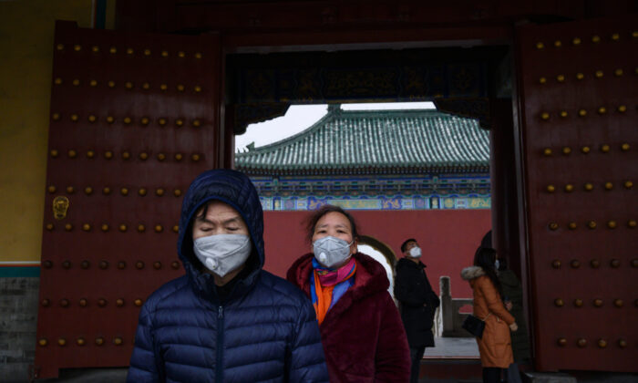 Les visiteurs chinois portent des masques de protection alors qu'ils visitent le Temple du Ciel, qui est resté ouvert pendant les vacances du Nouvel An chinois et du Festival du printemps à Pékin, en Chine, le 27 janvier 2020. (Kevin Frayer/Getty Images)