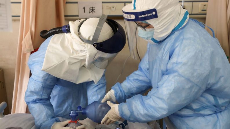 Des membres du personnel médical soignent un patient infecté par le nouveau coronavirus à l'hôpital de la Croix-Rouge de Wuhan, en Chine, le 16 février 2020. (TR/AFP via Getty Images)