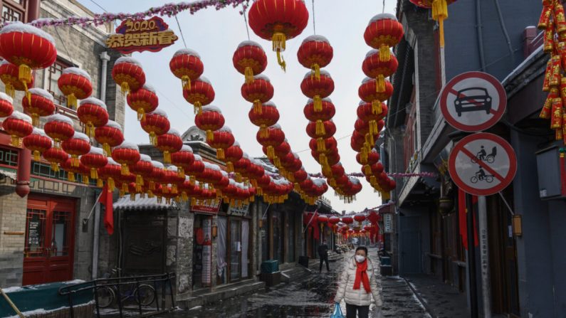 Une Chinoise porte un masque de protection alors qu'elle marche dans une rue commerciale presque vide et fermée à Pékin, en Chine, le 7 février 2020. (Kevin Frayer/Getty Images)