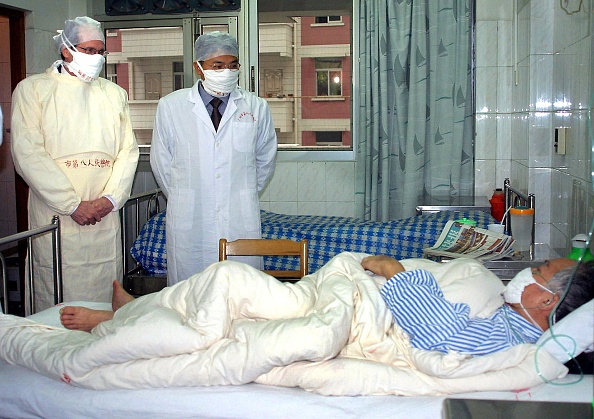 -Illustration archives- L'expert de l'Organisation mondiale de la santé (OMS) accompagné d'un médecin chinois non identifié, examine un patient, « nous ne sommes pas en phase de pandémie ». Photo par STR / AFP via Getty Images.