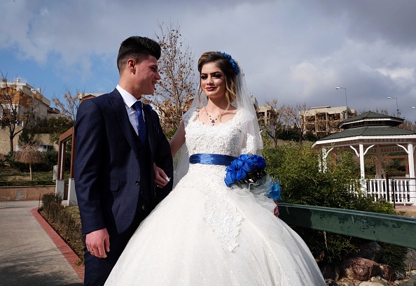 -Sundus Garis, 16 ans, et Farid Mallo, 19 ans, tous deux de la communauté yézidie assiégée qui ont été déplacés de la région de Sinjar, dans le nord de l'Irak, lors d'une séance photo après leur cérémonie de mariage à Dohuk, le 23 janvier 2020. Photo par SAFIN HAMED / AFP via Getty Images.