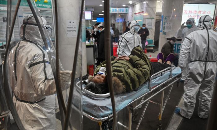 Des membres du personnel médical portent des vêtements de protection arrivent avec un patient à l'hôpital de la Croix-Rouge de Wuhan, en Chine, le 25 janvier 2020. (Hector Retamal/AFP via Getty Images)