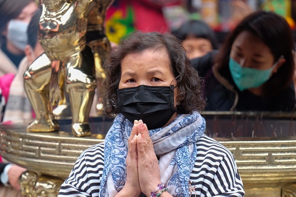 Une femme portant un masque de protection prie au temple de Lungshan lors du quatrième jour du nouvel an lunaire du rat à Taipei le 28 janvier 2020. (Photo : SAM YEH/AFP via Getty Images)