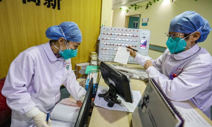 Des membres du personnel médical portant un masque s'entretiennent dans un hôpital de Wuhan, en Chine, le 30 janvier 2020. (STR/AFP via Getty Images)
