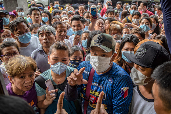 -Les Philippins espèrent acheter une foule de masques faciaux à l'extérieur d'un magasin de fournitures médicales qui a été perquisitionné par la police pour avoir prétendument surfacturé les masques, alors que la peur du public à propos du coronavirus chinois de Wuhan augmente, le 31 janvier 2020 à Manille. Photo par Ezra Acayan / Getty Images.