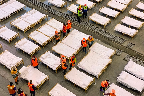 Les travailleurs ont installé des lits dans un centre d'exposition qui a été transformé en hôpital à Wuhan dans la province du Hubei en Chine le 4 février 2020. (Photo : STR/AFP via Getty Images)