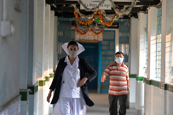 -Le personnel médical porte un masque marche dans une salle d'isolement ouverte à titre préventif à la suite d'une épidémie de virus du type SRAS qui a commencé dans la ville chinoise de Wuhan, à l’Hopital de Siliguri le 4 février 2020. Photo de DIPTENDU DUTTA / AFP via Getty Images.
