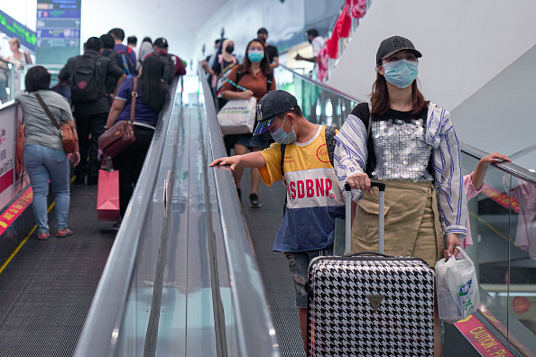 -Des visiteurs portant des masques traversent l'aéroport international de Kuala Lumpur 2 le 4 février 2020, Malaisie. Photo par Ore Huiying / Getty Images.