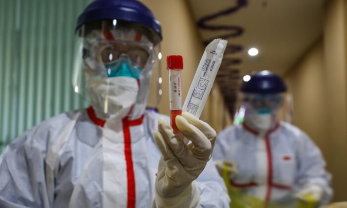 Un membre du personnel médical montrant une éprouvette après avoir prélevé des échantillons sur une personne devant être testée pour le nouveau coronavirus dans une zone en quarantaine de la ville de Wuhan, dans la province de Hubei, en Chine, le 4 février 2020. (STR/AFP via Getty Images)