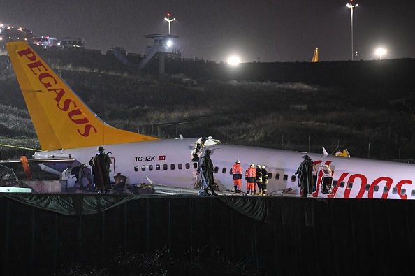 Des soldats turcs montent la garde alors que les sauveteurs s'efforcent d'extraire les passagers du crash d'un Boeing 737 de Pegasus Airlines, après qu'il ait dérapé sur la piste lors de l'atterrissage à l'aéroport Sabiha Gokcen d'Istanbul le 5 février 2020. (Photo : OZAN KOSE/AFP via Getty Images)