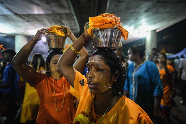 -Des dévots hindous portent des pots de lait sur la tête comme offrandes alors qu'ils se dirigent vers le temple de Batu Caves pendant le festival Thaipusam à Batu Caves à la périphérie de Kuala Lumpur, le 7 février 2020. Photo de Mohd RASFAN / AFP via Getty Images.