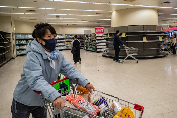 -Des acheteurs portant des masques faciaux poussent des caddies devant des étagères vides à l'intérieur d'une épicerie le 9 février 2020 à Hong Kong, Chine. photo d'Anthony Kwan / Getty Images.