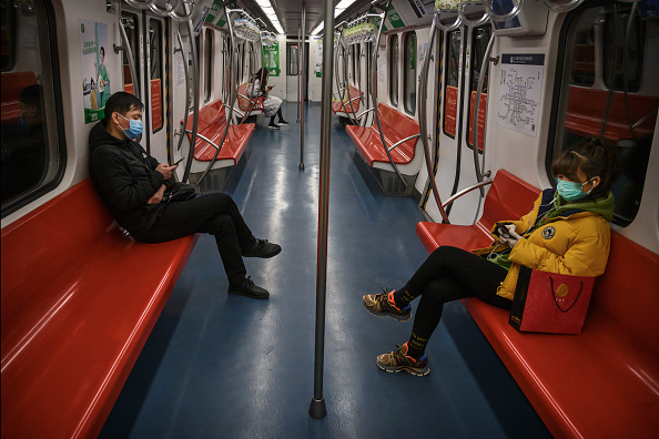 Les gens portent des masques de protection  dans le métro presque vide pendant la période de pointe du soir le 10 février 2020 à Pékin, en Chine.(Photo : Kevin Frayer/Getty Images)