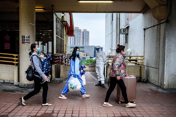 Les résidents portant des masques faciaux marchent à l'extérieur de Hong Mei House au Cheung Hong Estate à Hong Kong le 11 février 2020. (Photo : ANTHONY WALLACE/AFP via Getty Images)
