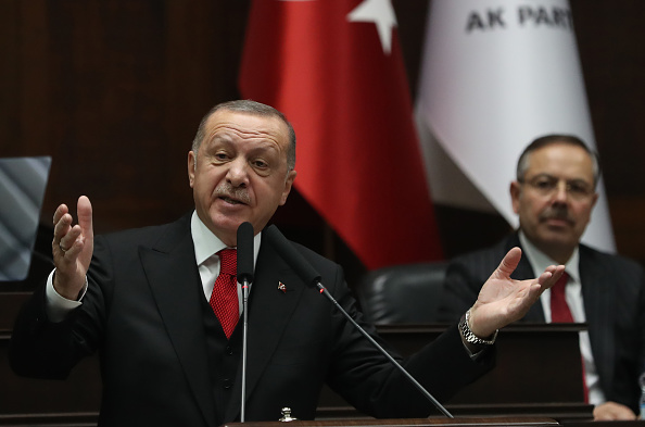 -Le président de la Turquie et leader du parti Justice et développement, Recep Tayyip Erdogan, salue l’assemblée alors qu'il assiste à la réunion du groupe du parti, Turquie à Ankara, le 12 février 2020. Photo Adem ALTAN / AFP via Getty Images.