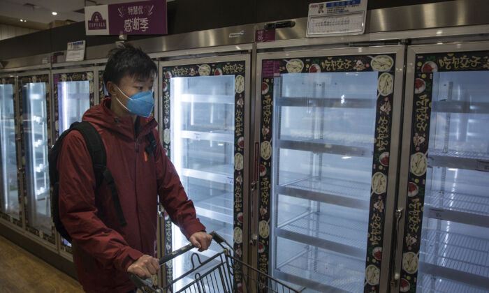 Un habitant passe devant des rayons vides dans un supermarché de Wuhan, en Chine, le 12 février 2020. (Getty Images)