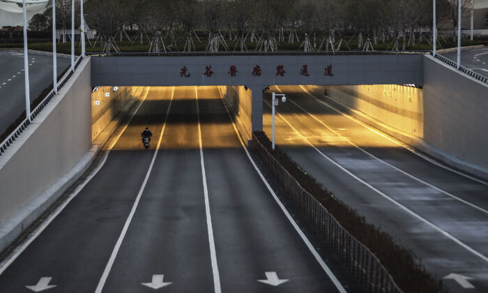 Un homme fait du vélo dans la rue vide d'Optical Valley à Wuhan, en Chine, le 16 février 2020. (Getty Images)