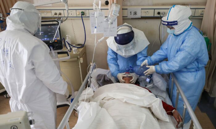 Des membres du personnel médical traitent un patient infecté par le nouveau coronavirus à l'hôpital de la Croix-Rouge de Wuhan, dans la province de Hubei, en Chine, le 16 février 2020. (STR/AFP via Getty Images)