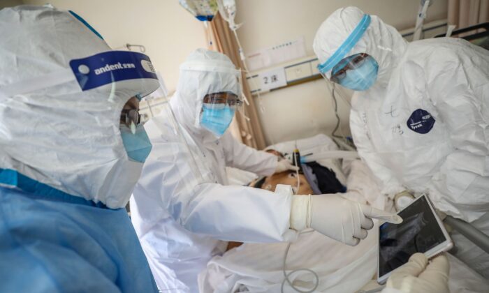 Un médecin regardant une image alors qu'il examine un patient infecté par le coronavirus de Wuhan à l'hôpital de la Croix-Rouge de Wuhan, dans la province centrale de Hubei en Chine, le 16 février 2020. (STR/AFP via Getty Images)

