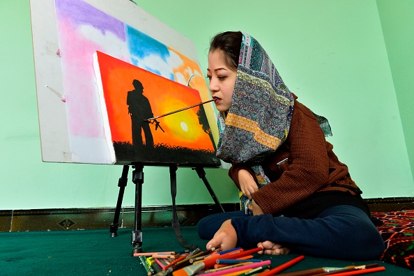-L’artiste afghane de 19 ans Robaba Mohammadi peint dans son atelier à Kaboul. Incapable d'utiliser ses mains, ses bras ou ses jambes, l'artiste a défié les probabilités improbables dans un pays qui discrimine régulièrement les femmes et les personnes handicapées. Photo de NOORULLAH SHIRZADA /AFP via Getty Images.
