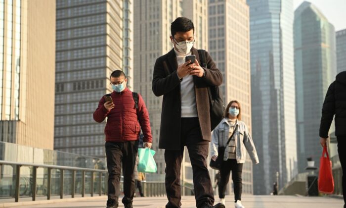 Des personnes portant des masques de protection sur un pont à Shanghai, le 24 février 2020. (Noel Celis/AFP via Getty Images)