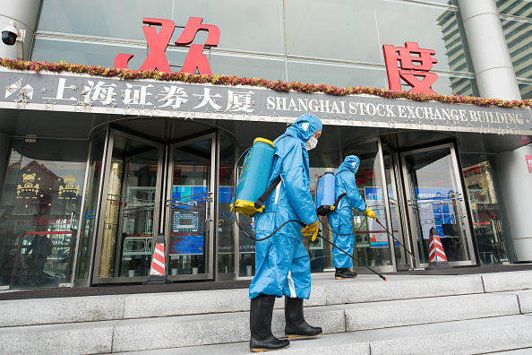 -Des travailleurs médicaux pulvérisent un antiseptique à l'extérieur de la porte principale du bâtiment de la Bourse de Shanghai le 03 février 2020, en Chine. Photo par Yifan Ding / Getty Images.