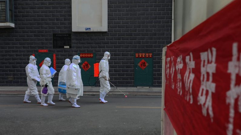 Des techniciens de laboratoire se déplacent lors d'une enquête épidémiologique à Linyi, dans la province orientale du Shandong, en Chine, le 10 février 2020. (STR/AFP via Getty Images)