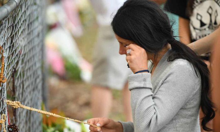 Leila Geagea s'arrête près des fleurs placées sur la scène où un véhicule a mortellement heurté trois de ses enfants dans la banlieue de Sydney, à Oatlands, le 2 février 2020. (Joel Carrett/AAP)