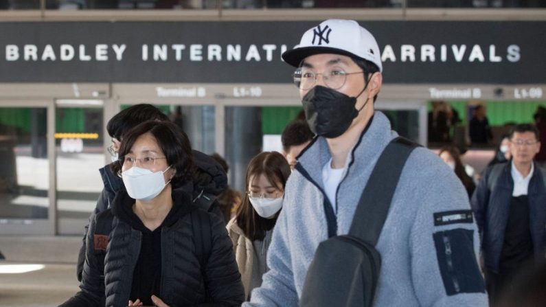  Les passagers portent des masques de protection contre la propagation du Coronavirus lorsqu'ils arrivent sur un vol en provenance d'Asie à l'aéroport international de Los Angeles, en Californie, le 29 janvier 2020. (Mark Ralston/AFP via Getty Images) 