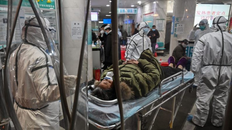 Des membres du personnel médical portant des vêtements de protection pour aider à stopper la propagation du virus mortel apparu dans la ville, arrivent avec un patient à l'hôpital de la Croix-Rouge de Wuhan, en Chine, le 25 janvier 2020. (Hector Retamal/AFP via Getty Images) 