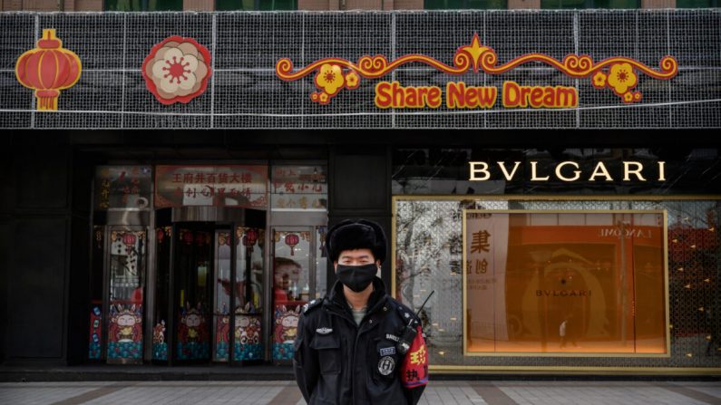 Un agent de sécurité chinois porte un masque de protection alors qu'il se tient dans une rue commerciale de Pékin, en Chine, le 18 février 2020. (Kevin Frayer/Getty Images)